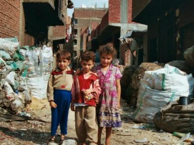 Drei verwahrloste Kinder neben Müll in den Straßen von Kairo